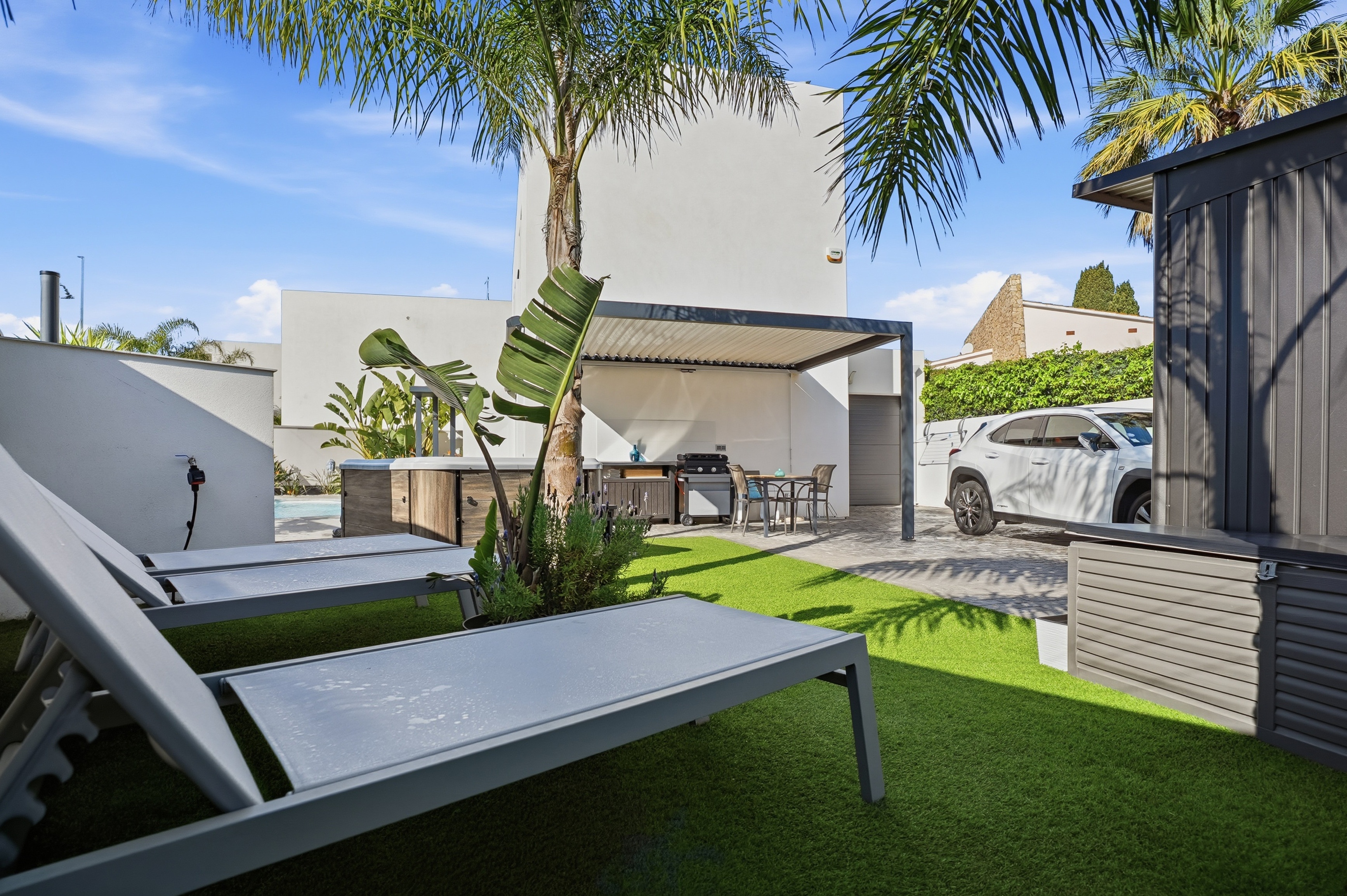 Jardín exterior con pérgola y palmeras fotografía inmobiliaria Costa Brava